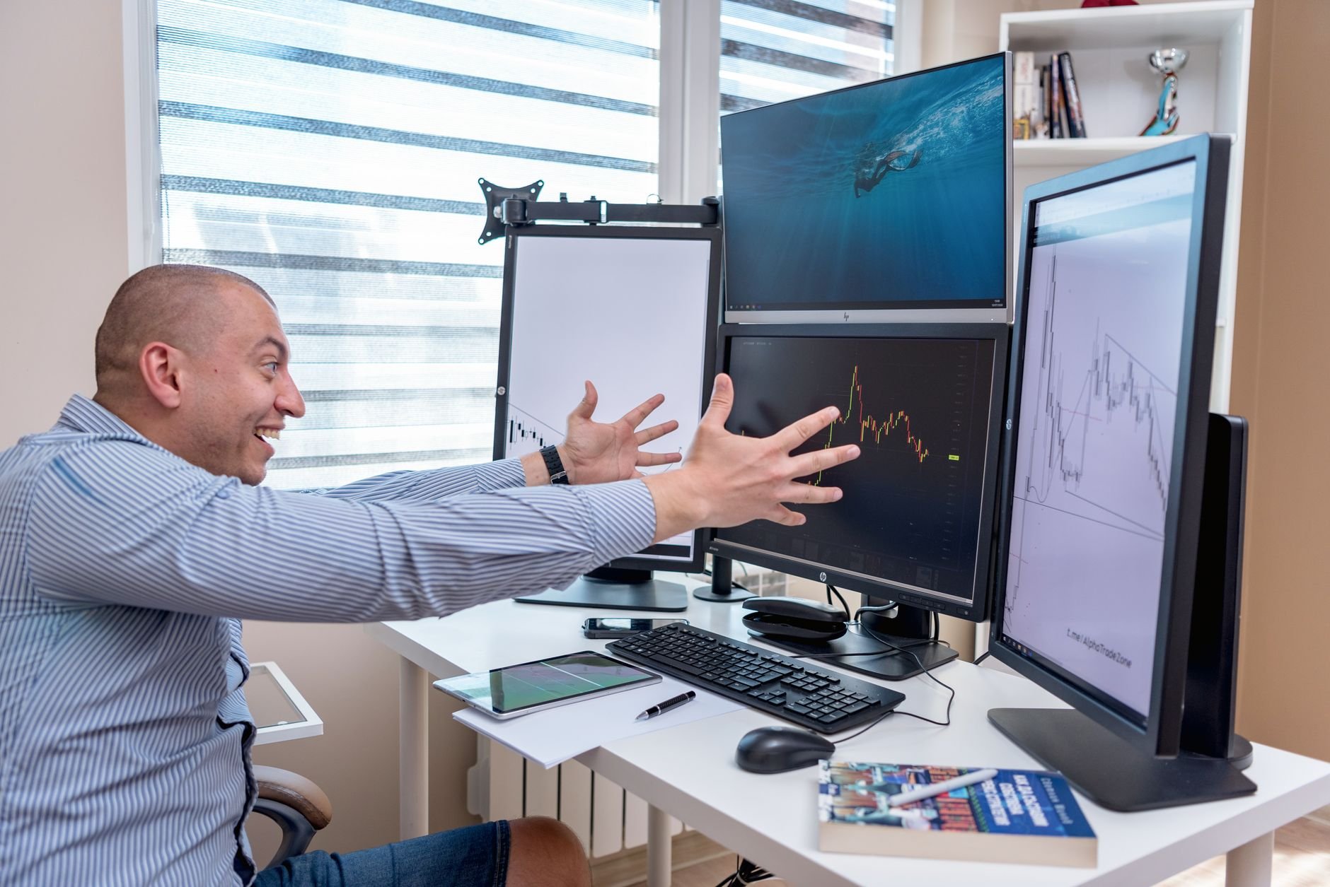 Joyful founder celebrating market success with multiple monitor setup showing analytics dashboards