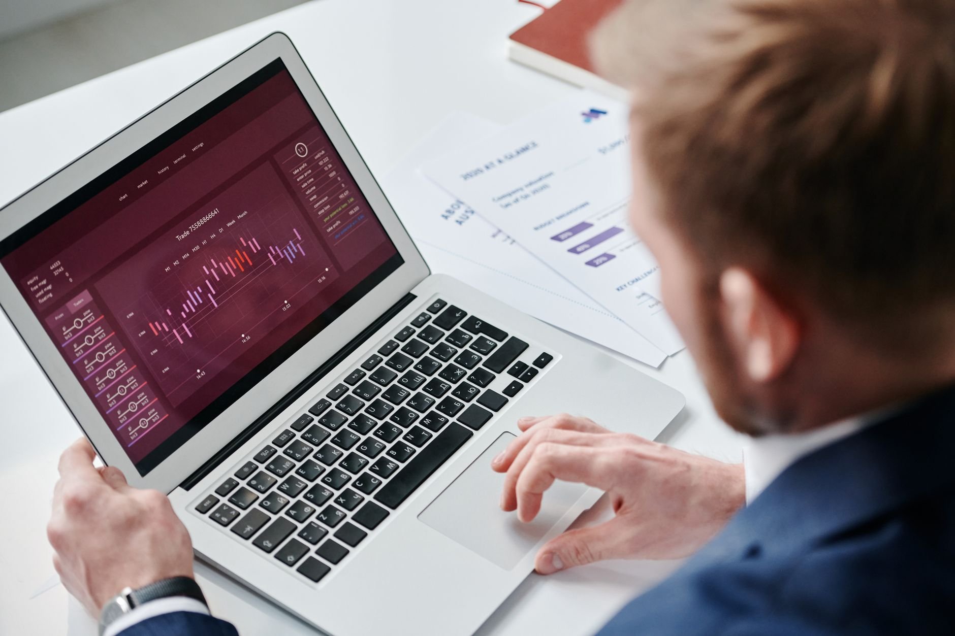 Businessman reviewing data analytics dashboard on laptop in bright office environment